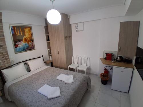 a bedroom with a bed with two towels on it at HELEN's ROOM in Artemida
