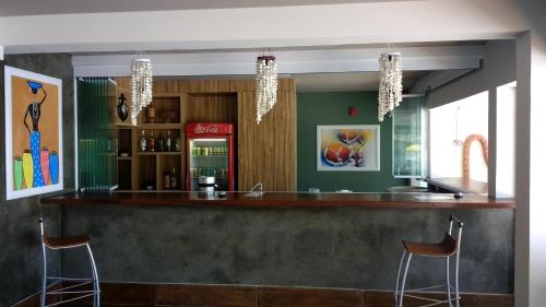 a bar in a restaurant with two stools at Kaakupe Praia Hotel in Guaratuba