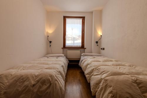 a row of beds in a room with a window at Casa Irene in Mareson