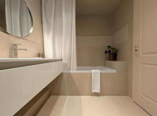 a white bathroom with a sink and a mirror at Provencal Escape - Suite in Saint Paul de Vence