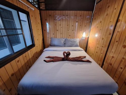 a room with a bed with twoeddy bears on it at Sabai Sabai Bed in Pai