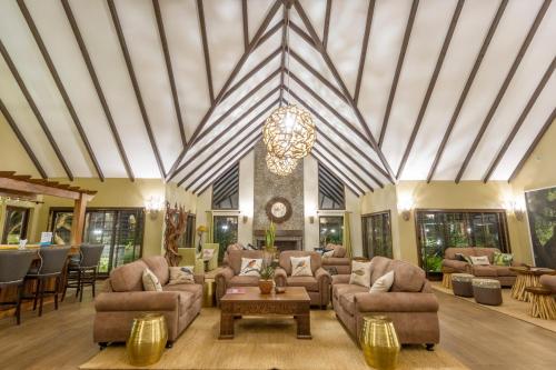 a large living room with couches and a chandelier at The Retreat at Ngorongoro in Karatu