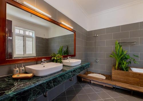a bathroom with two sinks and a large mirror at AnNam Village 4 in Vung Tau