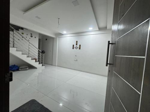 a white room with a staircase and a door at Harmony Palace in Nashik