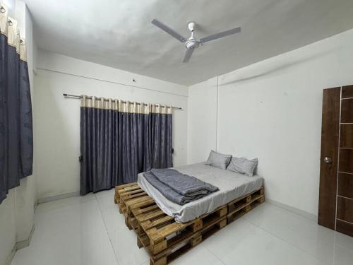 a bed in a room with a ceiling fan at Harmony Palace in Nashik