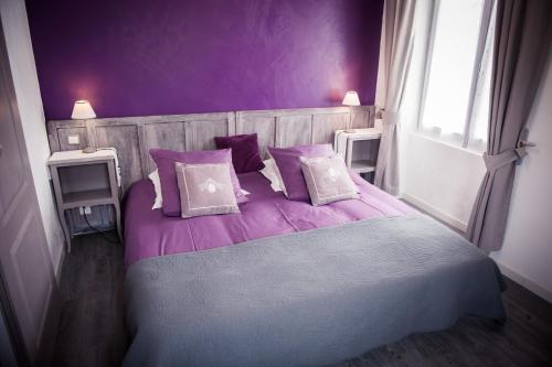 - une chambre violette avec un lit doté de draps et d'oreillers violets dans l'établissement Chambres d'hôtes La Combe de Redoles, à Tour-de-Faure