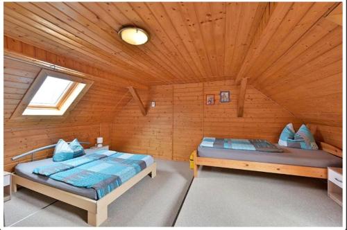 a bedroom with two beds in a log cabin at Gerstels Ferienhof in Hörselberg-Hainich