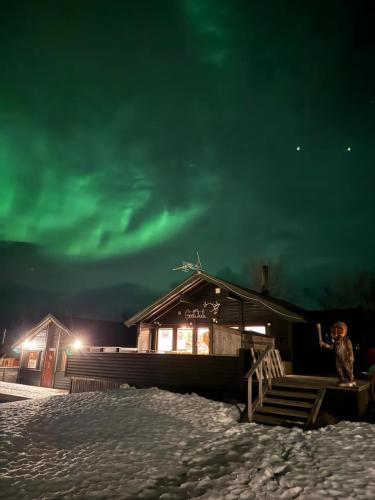 a person standing in front of a building at night at Big cabin in Lyngen Fjords in Jægervatnet