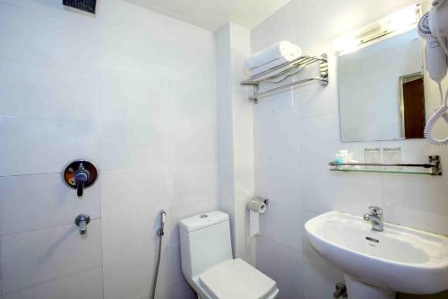 ein weißes Badezimmer mit Toilette und Waschbecken in der Unterkunft Hotel Central Prime in Kathmandu