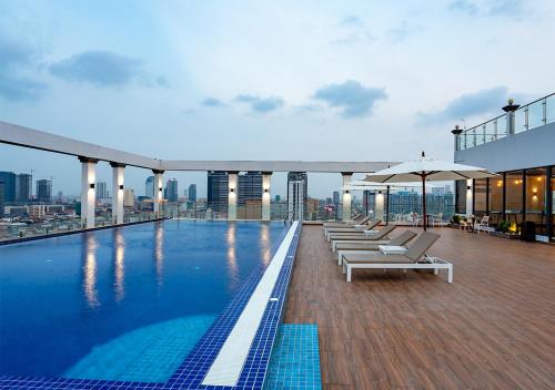 a pool on top of a building with chairs and umbrellas at LN Hotel & Residence in Phnom Penh