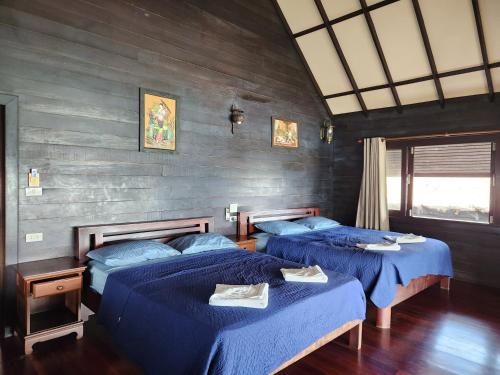 two beds in a room with blue sheets at Ko Phangan Beach Cottages in Ban Tai