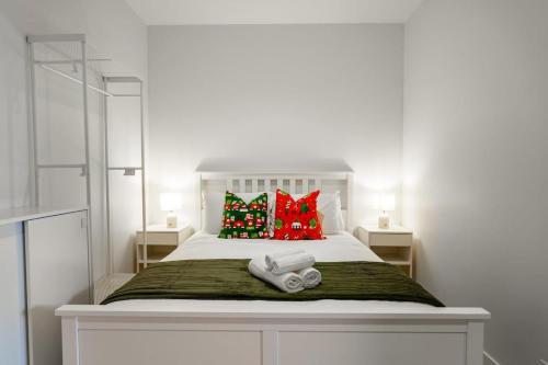 a bedroom with a white bed with red pillows at Premium South Melb 2 Queens Study Pool & Gym in Melbourne