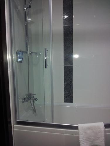 a shower in a bathroom with a glass door at Vesta Fuar Otel in Konak
