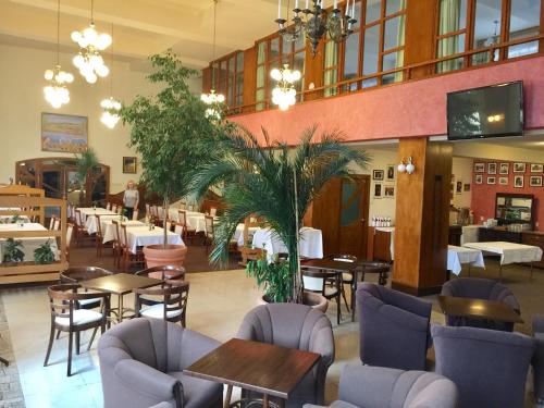 a dining room with tables and chairs and a restaurant at Hotel & Penzión Grand Matej in Banská Štiavnica