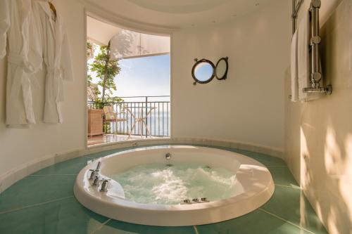 a jacuzzi tub in a room with a balcony at Hotel Santa Caterina in Amalfi