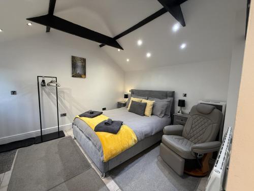 a bedroom with a bed and a chair at Crossways Beech Tree in Grimsby