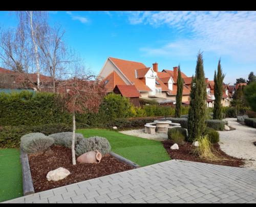 a yard with a garden with a statue of a cactus at Pupi Apartmanház in Balatonlelle