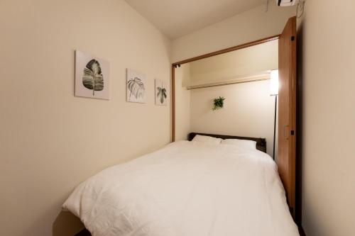 a bedroom with a white bed and a mirror at NTK House Yokohama in Yokohama