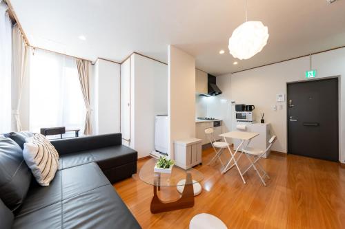 a living room with a couch and a table at NTK House Yokohama in Yokohama