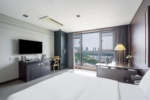 a hotel room with a large bed and a television at 브라운도트호텔 인천 송도 Browndot Hotel Incheon Songdo in Incheon