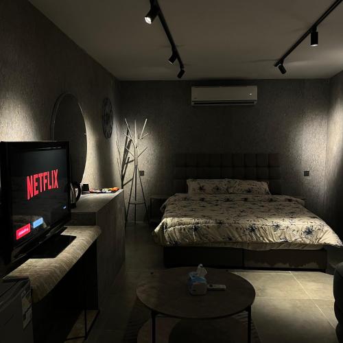 a bedroom with a bed and a tv and a table at استديو المنام الراقي in Medina