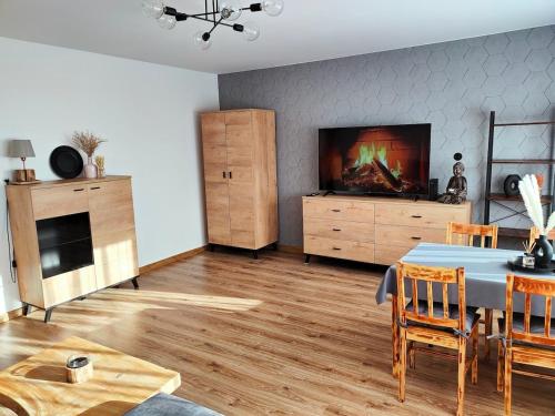 a living room with a table and a tv at Apartament Prudniczanka in Prudnik