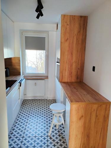 a kitchen with a wooden counter and a stool at Apartament Prudniczanka in Prudnik