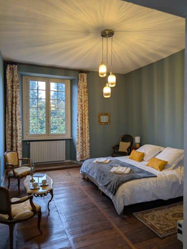 a bedroom with a large bed and a table at Château du Mas de l'Âge in Couzeix