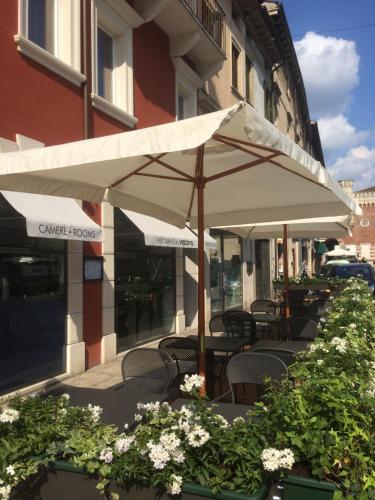 a patio with tables and umbrellas in front of a building at Locanda al Vescovo & SPA in Verona