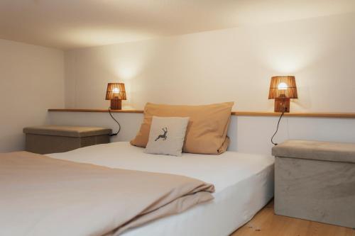a bedroom with two beds and two lamps on the wall at Seabreeze Suite in Füssen