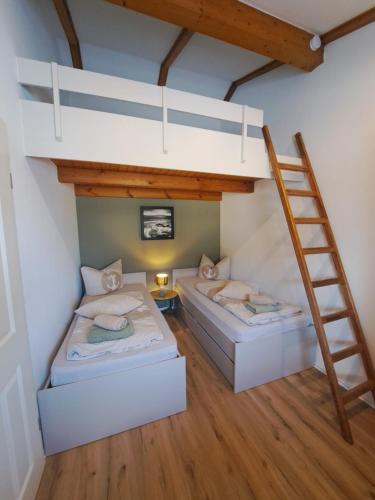 two beds in a room with a ladder at Watt'n Traum in Butjadingen