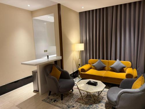 a living room with a yellow couch and chairs at Belvedere Hotel in Medina