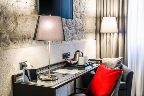 a desk in a hotel room with a red pillow at Locanda al Vescovo & SPA in Verona