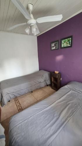 a room with two beds and a ceiling fan at Hospedaje "LUZ" in Olavarría