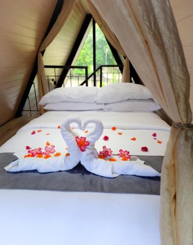a bed with two swans made out of flowers at Inato Suites- Teepee House in Panglao Island