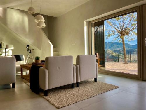 a living room with two chairs and a large window at Casa Romeriko piscina privada vistas espectaculares Valle de Ricote Murcia in Ricote