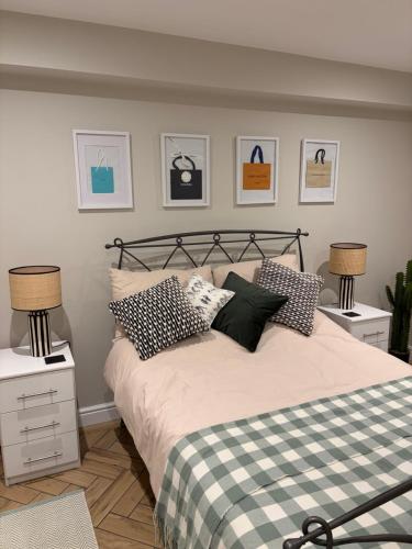 a bedroom with a bed and two lamps and pictures on the wall at The Annexe, The Walled Garden- Nr Bicester Village in Bicester