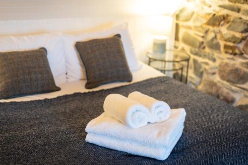 a hotel room with towels on a bed at Plockton Distillery Flat in Plockton