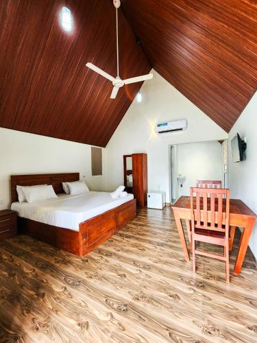 a bedroom with a bed and a wooden ceiling at Pearl Villa Katunayake in Katunayaka
