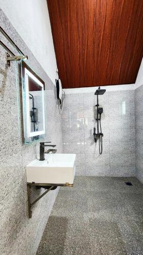 a bathroom with a white sink and a mirror at Pearl Villa Katunayake in Katunayaka