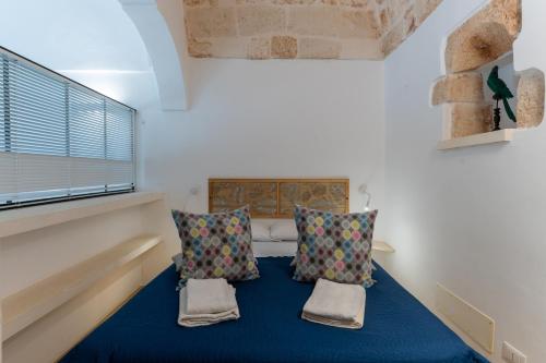 a room with a bed with two pillows and a window at Suite Diffuse - Widespread Suite Collection PCB LUXURY in Ostuni