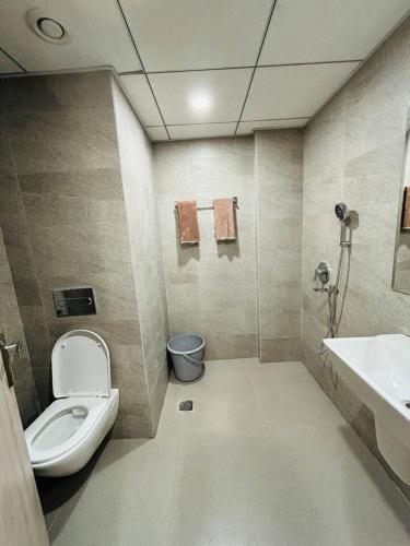 a bathroom with a toilet and a sink at The Pineapple Suite with Gorgeous Views in Greater Noida