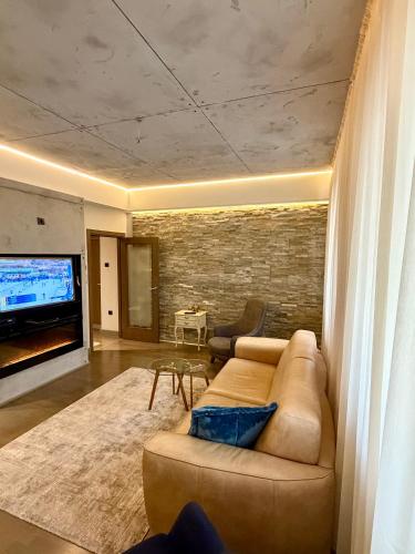 a living room with a couch and a flat screen tv at smgold lux apartman in Podgorica