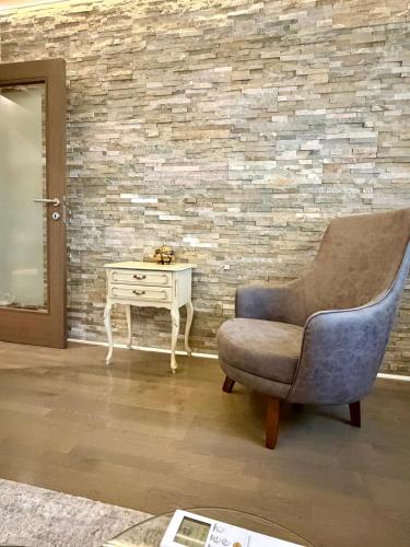 a living room with a chair and a table at smgold lux apartman in Podgorica