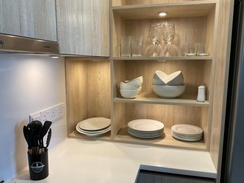 a kitchen with plates and wine glasses on shelves at Royal Wave, Beachfront, Nilaveli in Trincomalee