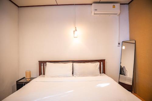 a bed in a small room with a mirror at Zen Rise in Ko Phangan