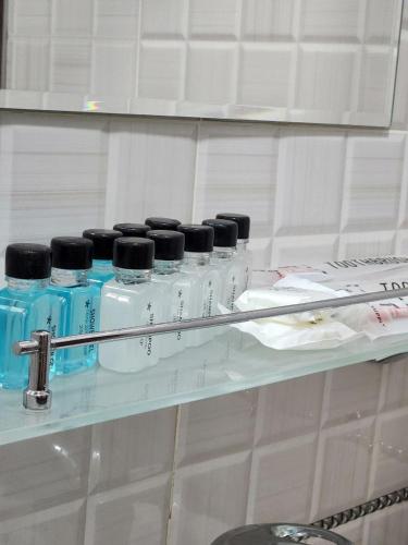 a shelf with a bunch of bottles on it at Mansarda hostel in Samarkand