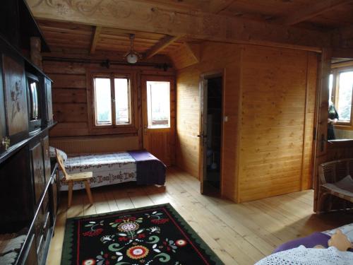 a room with a bed in a wooden cabin at Pokoje Gościnne Kościelisko AZ Somatic in Kościelisko