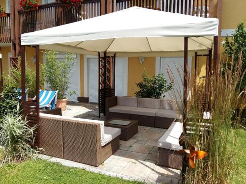 a patio with a white umbrella and benches at Appartement Landhaus Felsenkeller in Sankt Kanzian