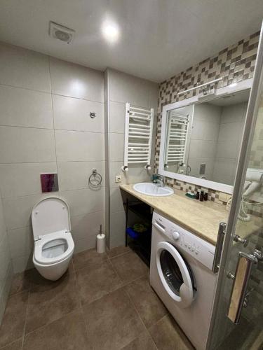 a bathroom with a toilet and a sink and a mirror at Orbi Palace Bakuriani in Bakuriani